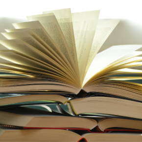 Stack of open books with the top one having pages open all 180 degrees